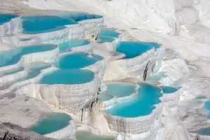 pamukkale的石灰华梯田充满了明亮的蓝色水，是土耳其最美丽的地方之一