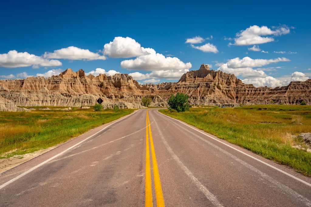 笔直的2车道公路穿过荒地国家公园的景观，是美国中西部最好的自驾游之一