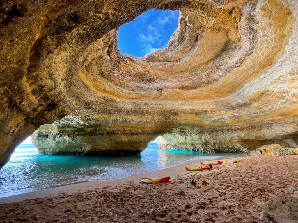 在葡萄牙阿尔加维贝纳吉尔洞穴的海滩边，皮划艇和餐板