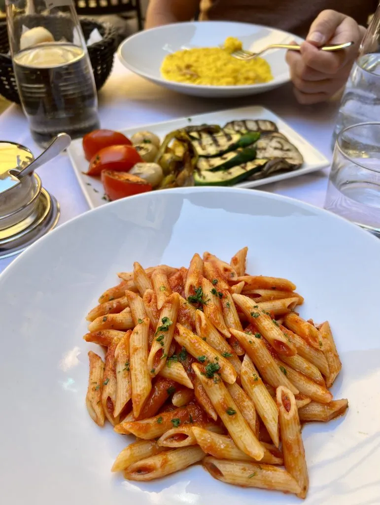 在bellagio餐厅Antico Pozzo Ristorante的桌子上有意大利面和意大利调味饭