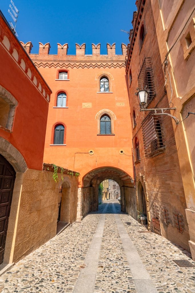 orange building leading into a short tunnel as seen when visiting castell'arquato italy
