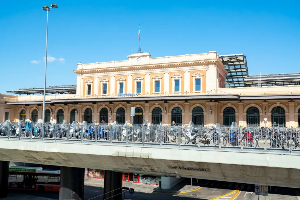 front facade of the parma train station with bikes parked in front