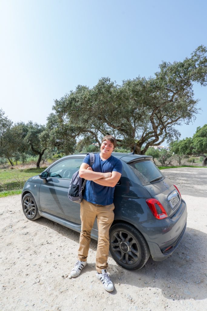 杰里米风暴和一辆租来的灰色汽车停在埃弗拉葡萄牙附近的巨石上