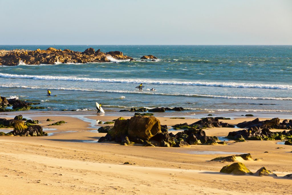 葡萄牙马托西尼奥斯的岩石海滩上有冲浪者，这是葡萄牙最好的沿海城镇之一
