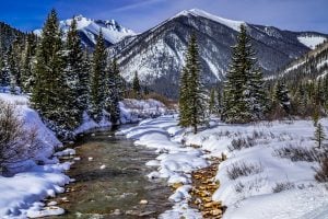 科罗拉多山脉的冬季景观，前景是河流，是美国最好的冬季假期之一