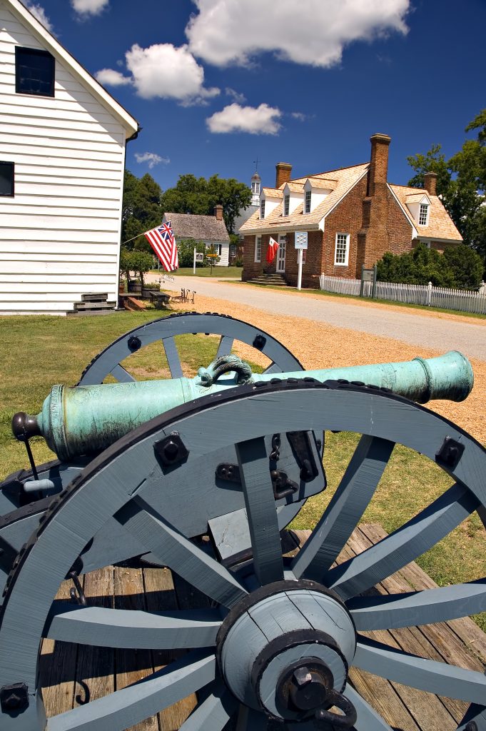 弗吉尼亚州约克镇的古董大炮，背景是历史建筑