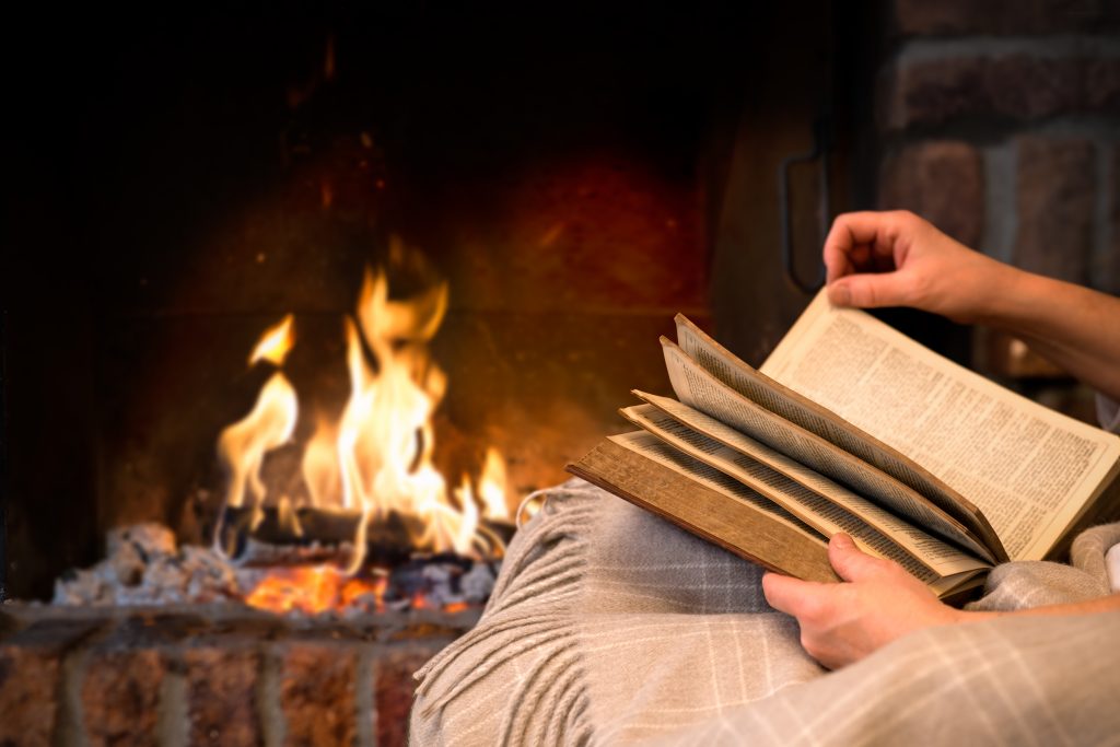 在美国最好的寒假之一，一个人在火炉前看书的特写
