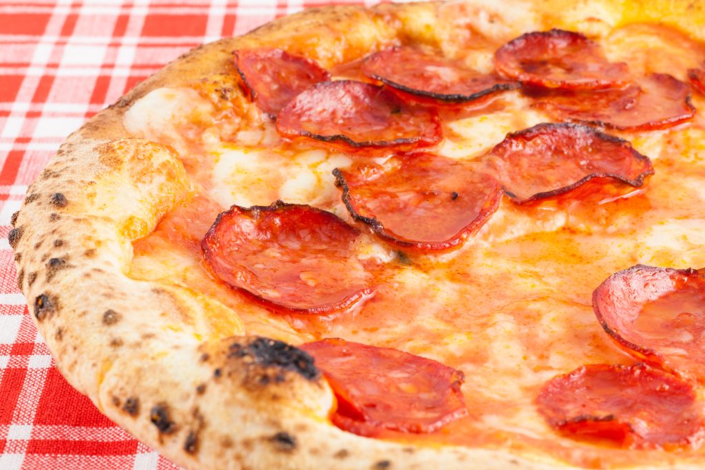 从侧面看披萨上的红色方格桌布，意大利披萨的提示